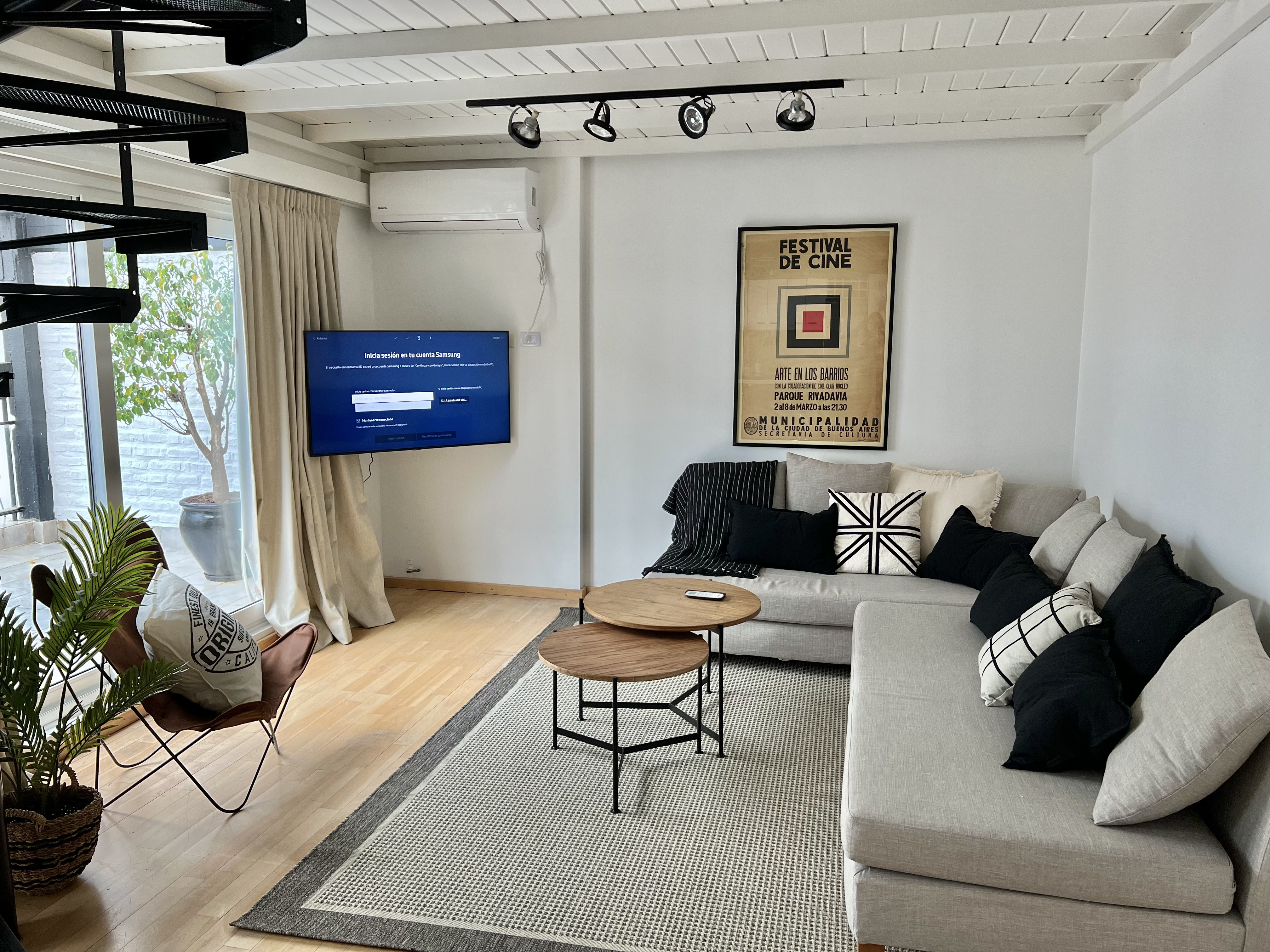 Living con sillón seccional, TV y escalera